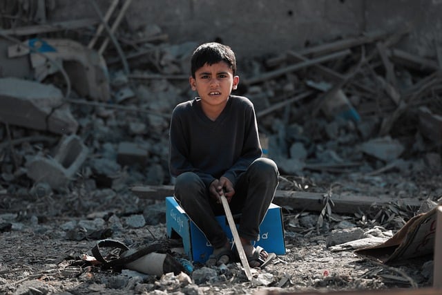Bambino di fronte a macerie a Gaza